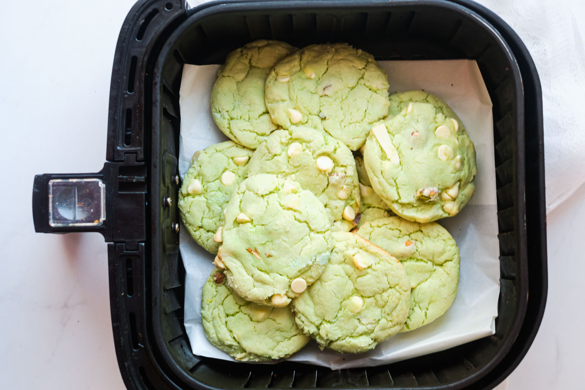 the completed air fryer pistachio pudding cookies in an air fryer basket and ready to serve