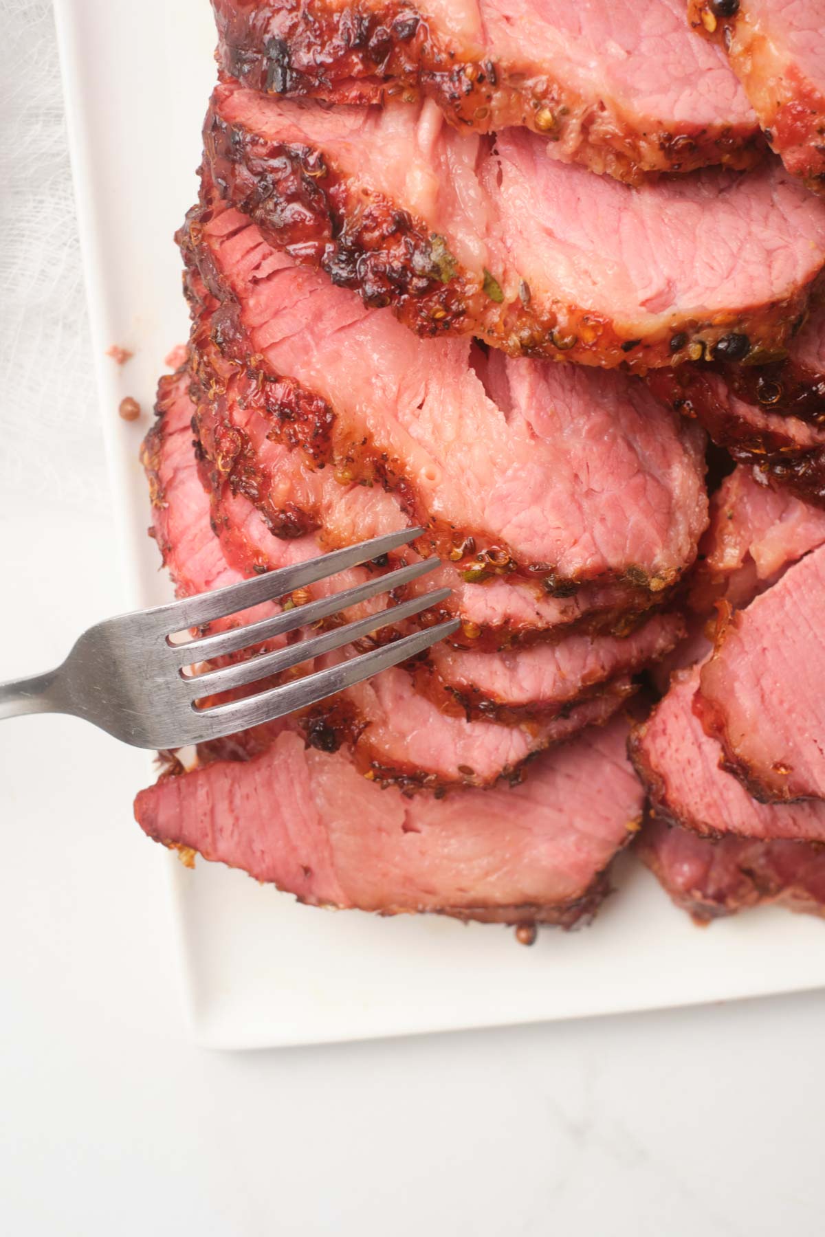 air fryer corned beef sliced and served on a white platter