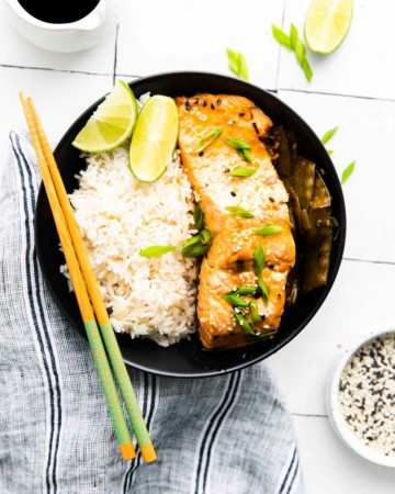 top down view of the completed instant pot salmon teriyaki recipe served with chopsticks, lime, sesame seeds and soy sauce.