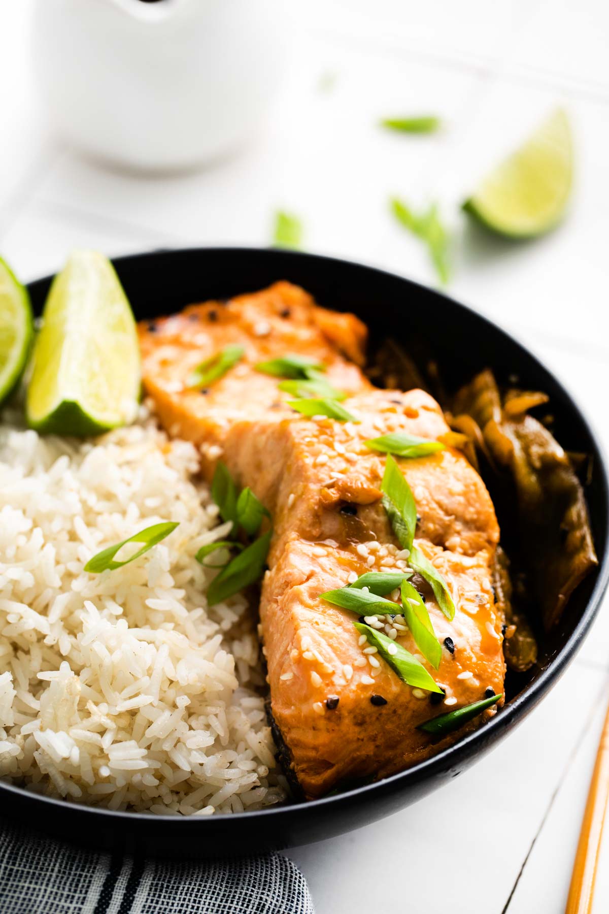 a black plate filled with instant pot salmon and steamed rice.