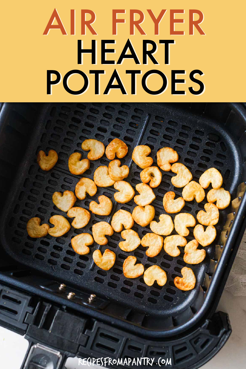 heart shaped small potato slices in an air fryer basket