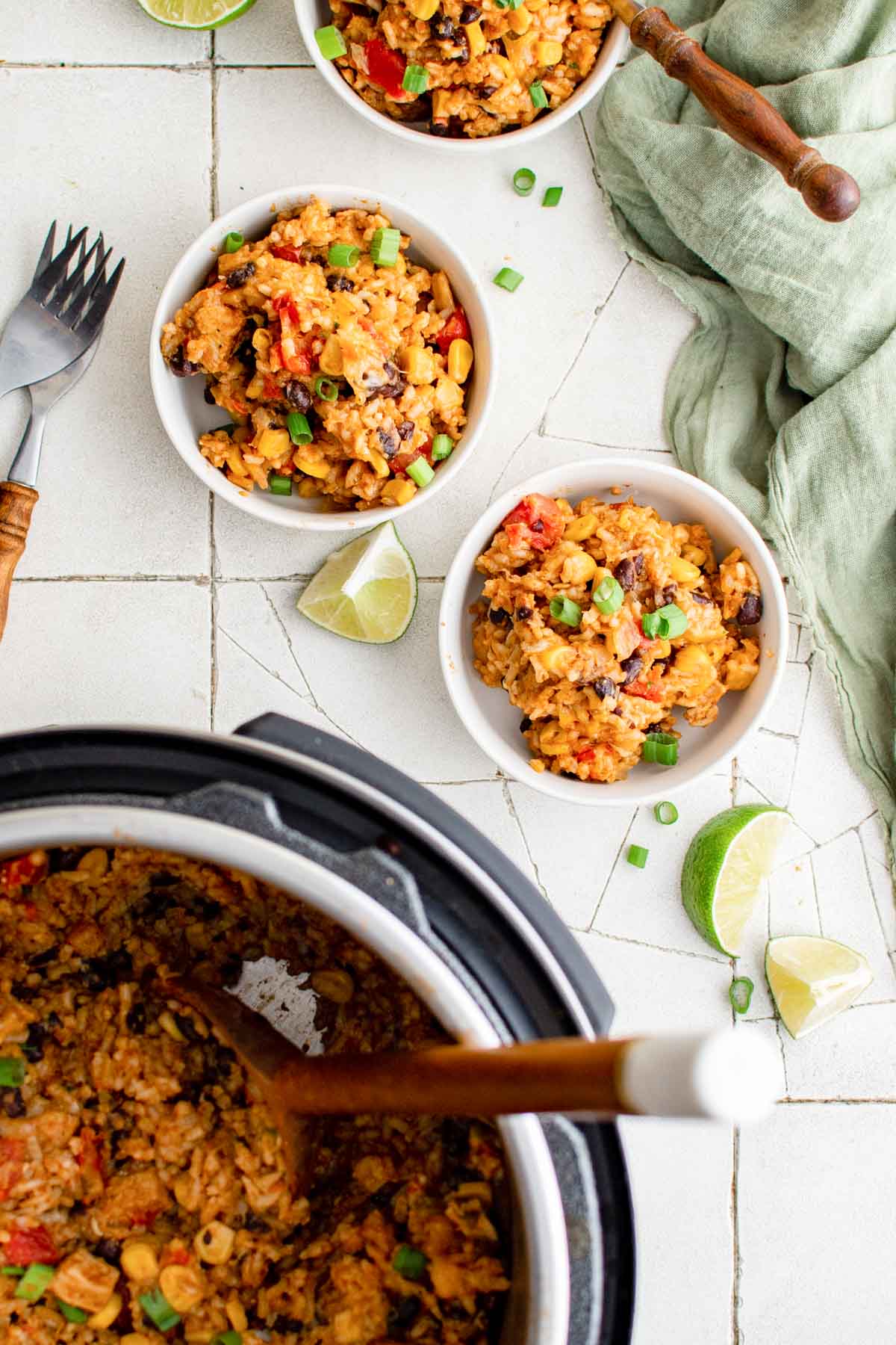 two servings of instant pot enchilada rice in white bowl sitting next to the instant pot