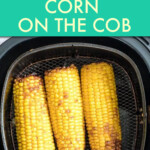 three corn cobs in an air fryer basket.