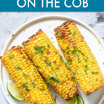 Three corn cobs on a plate garnished with cilantro