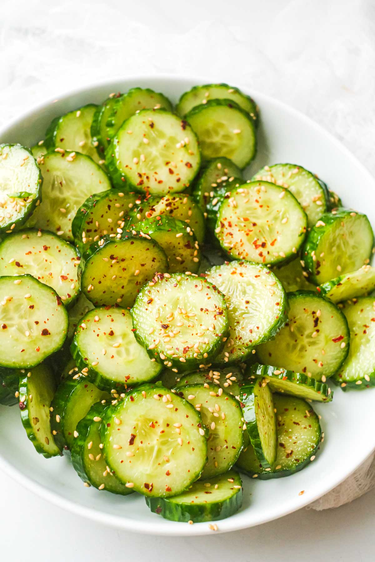 the finished asian cucumber salad recipe in a white serving bowl