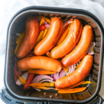 cooked brats and onions and peppers in the air fryer