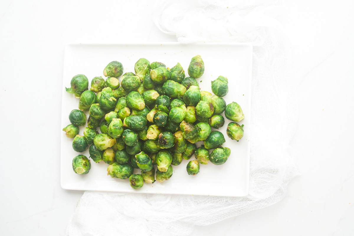 top down view of the finished how to cook frozen brussel sprouts served on a white platter