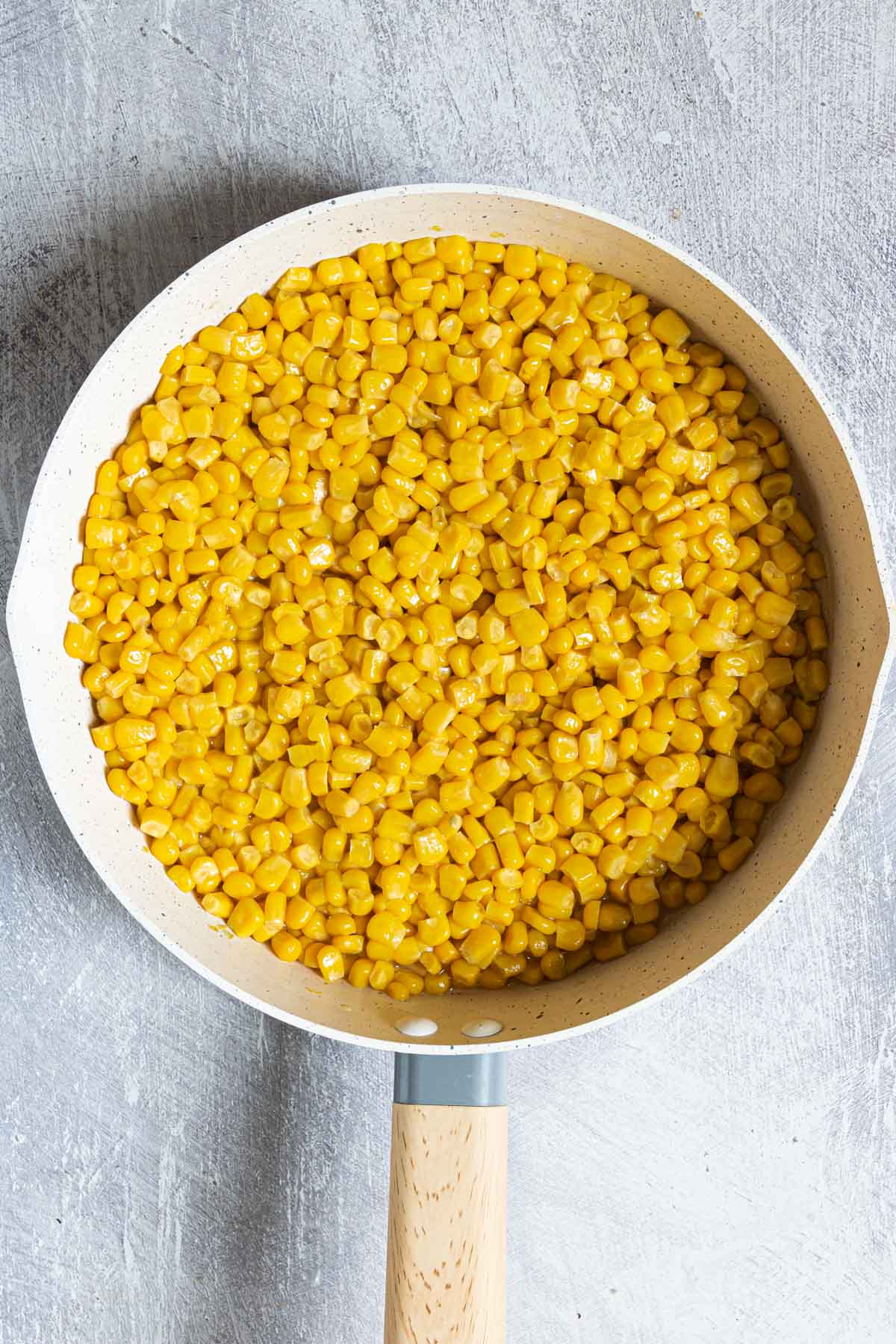 top down view of a saucepan filled with canned corn for the how to cook canned corn recipe