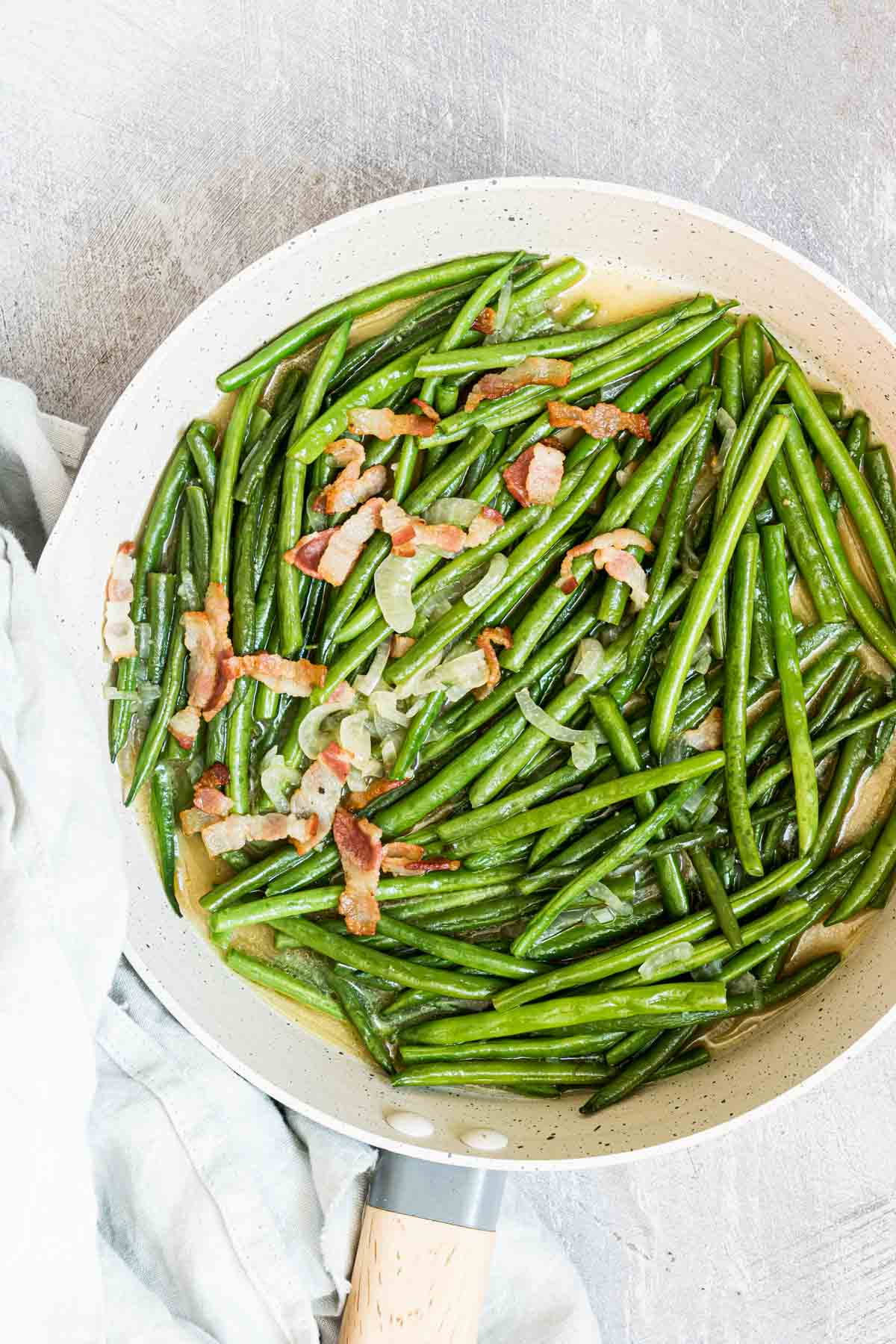 the finished smothered green beans in a pan and ready to serve