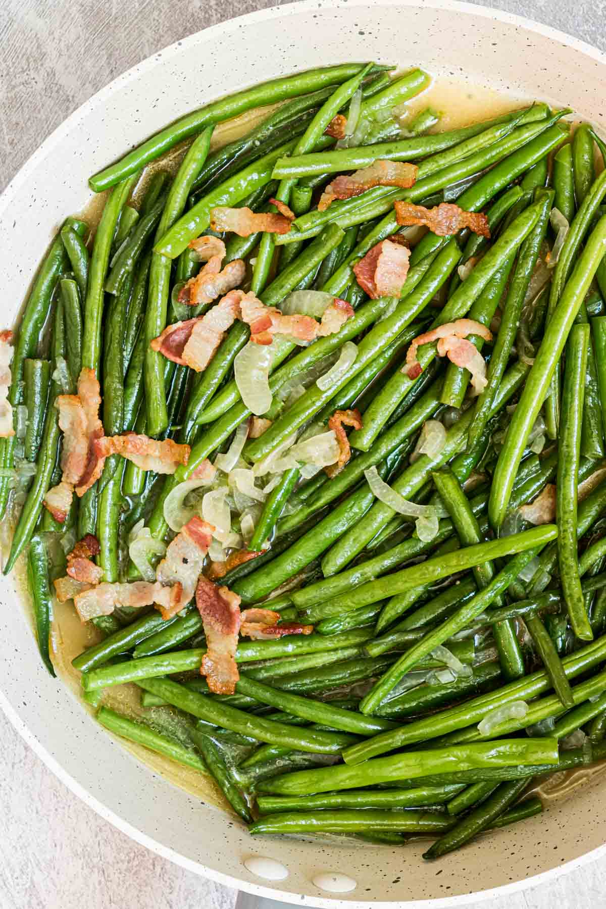 smothered green beans with bacon served in a ceramic dish