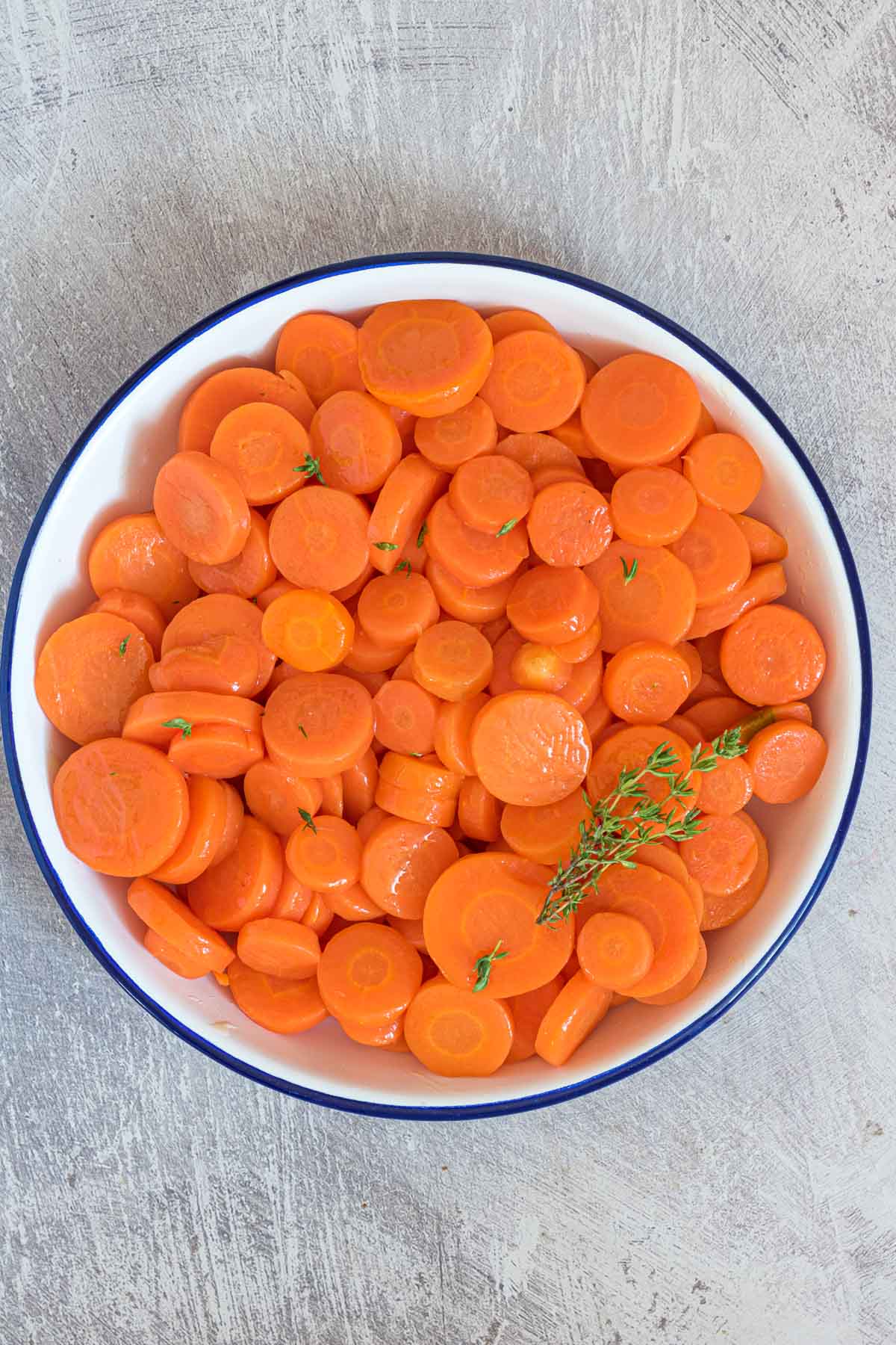the cooked carrots in a serving bowl with fresh herb garnish