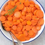 the cooked frozen carrots in a serving bowl with spoons