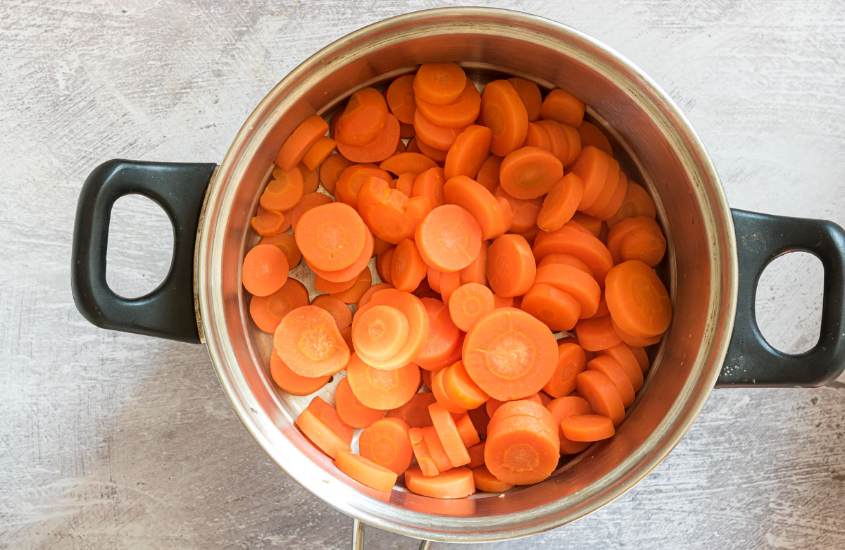 top down view of carrots in a steamer basket inside a cooking pot
