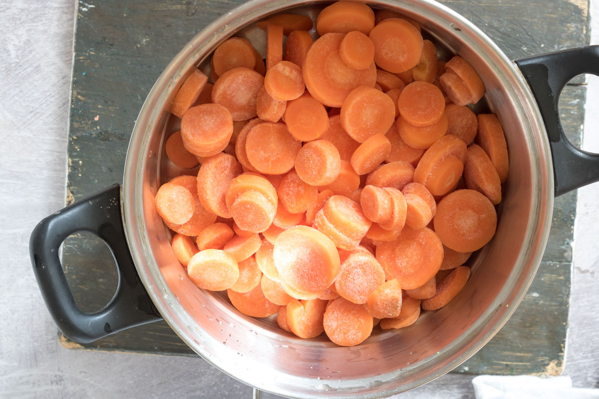 top down view of frozen carrots in a steamer pot