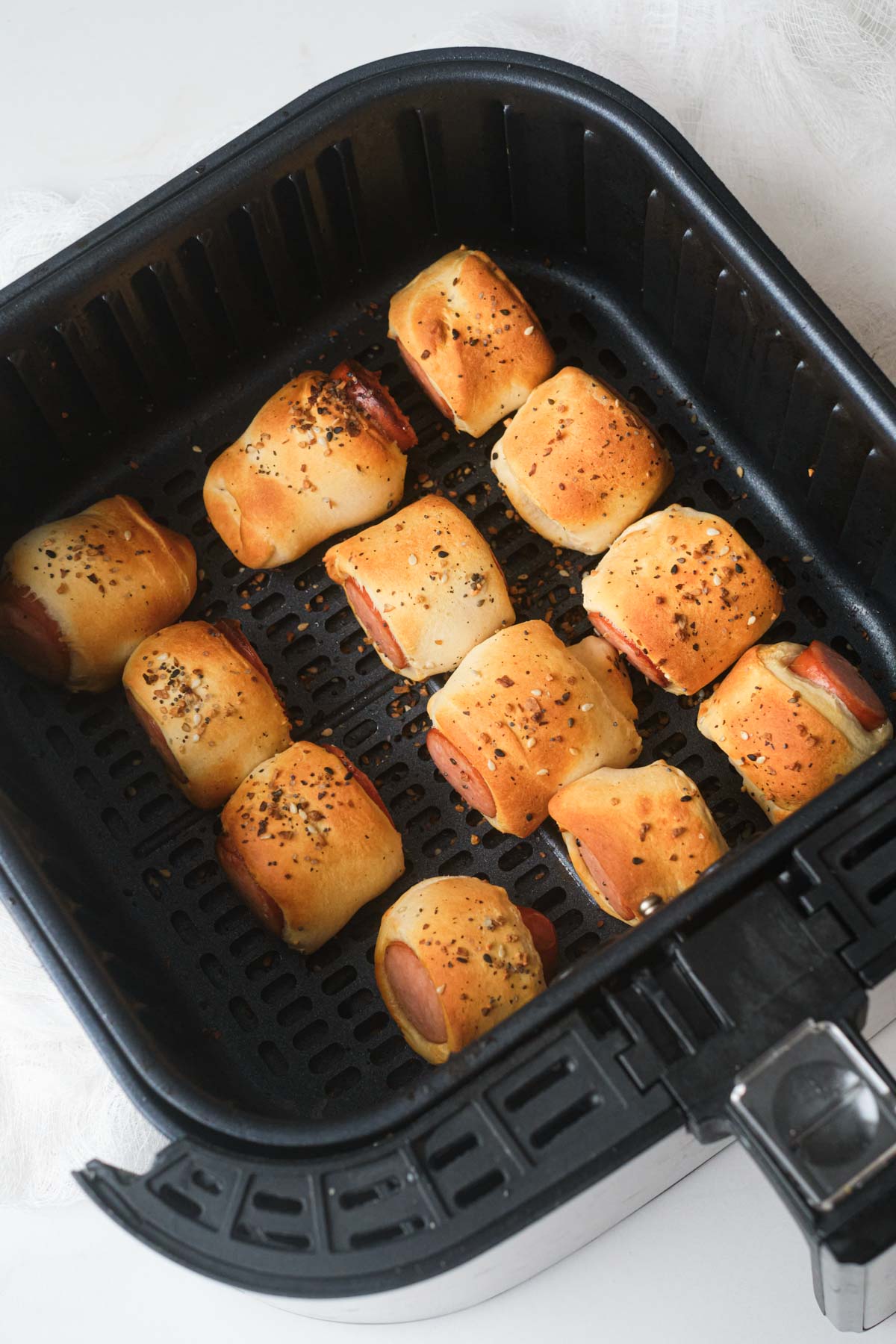 top down view of the completed air fryer sausage rolls inside the air fryer basket