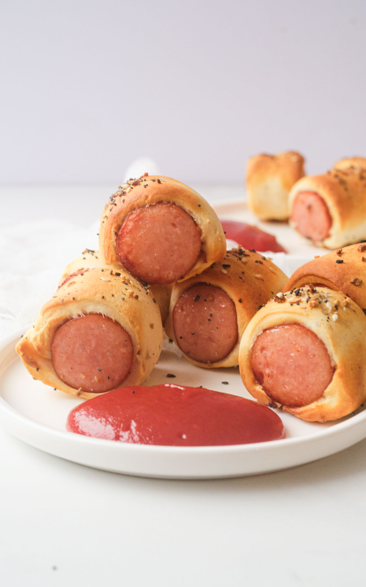 the finished air fryer sausage rolls on a plate with a side of ketchup