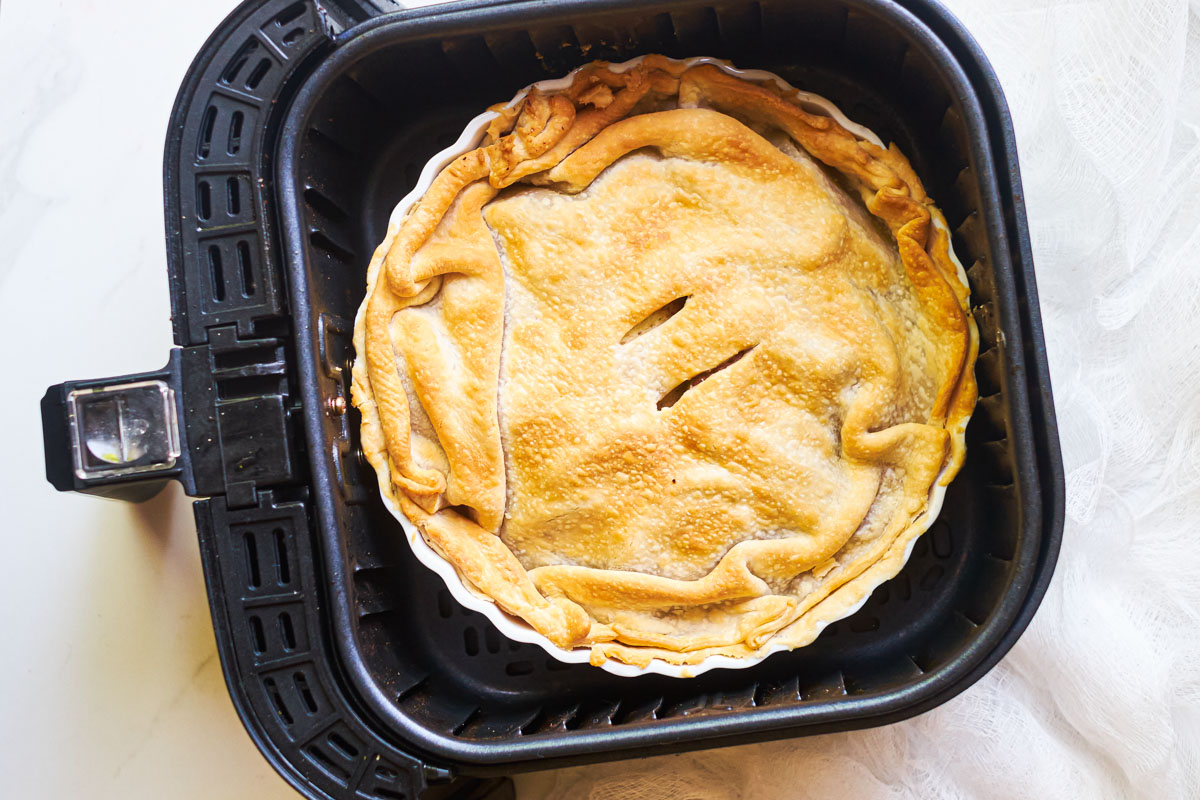 the cooked air fryer apple pie inside the air fryer basket