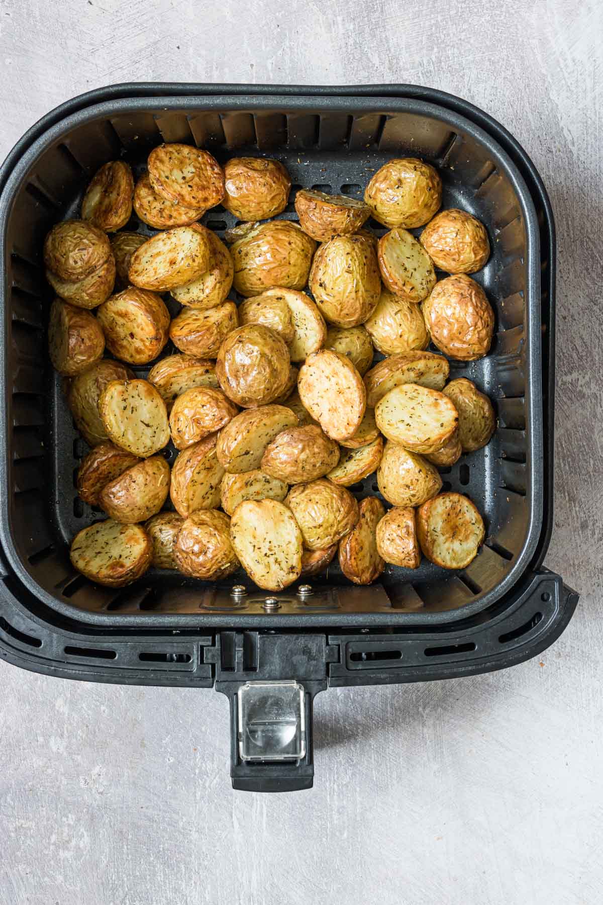 top down view of mini potatoes in air fryer basket
