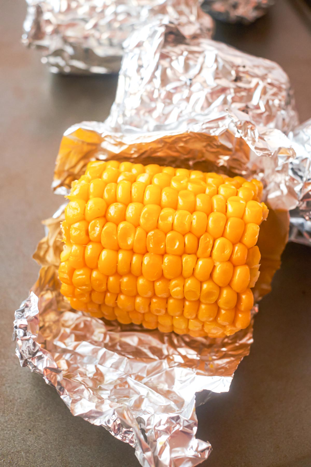 a piece of corn on the cob in the oven unwrapped and ready to serve