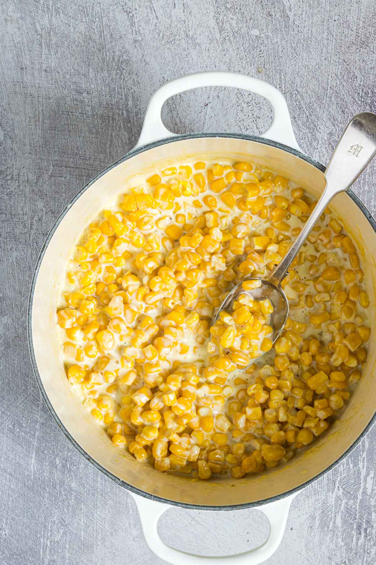 the completed creamed corn recipe in a white pot