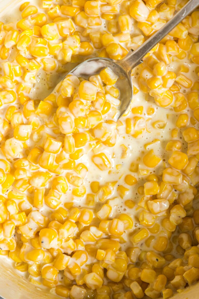 close up view of the creamed corn with a serving spoon inside