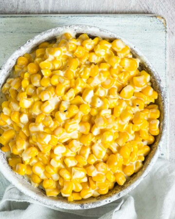the finished creamed corn recipe in a serving bowl with a cloth napkin