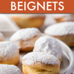 Close up of beignets topped with powdered sugar on a plate