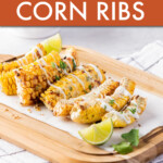 Corn ribs on a cutting board with sliced limes