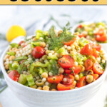 A bowl of Israeli couscous with vegetables, garnished with cherry tomatoes and dill