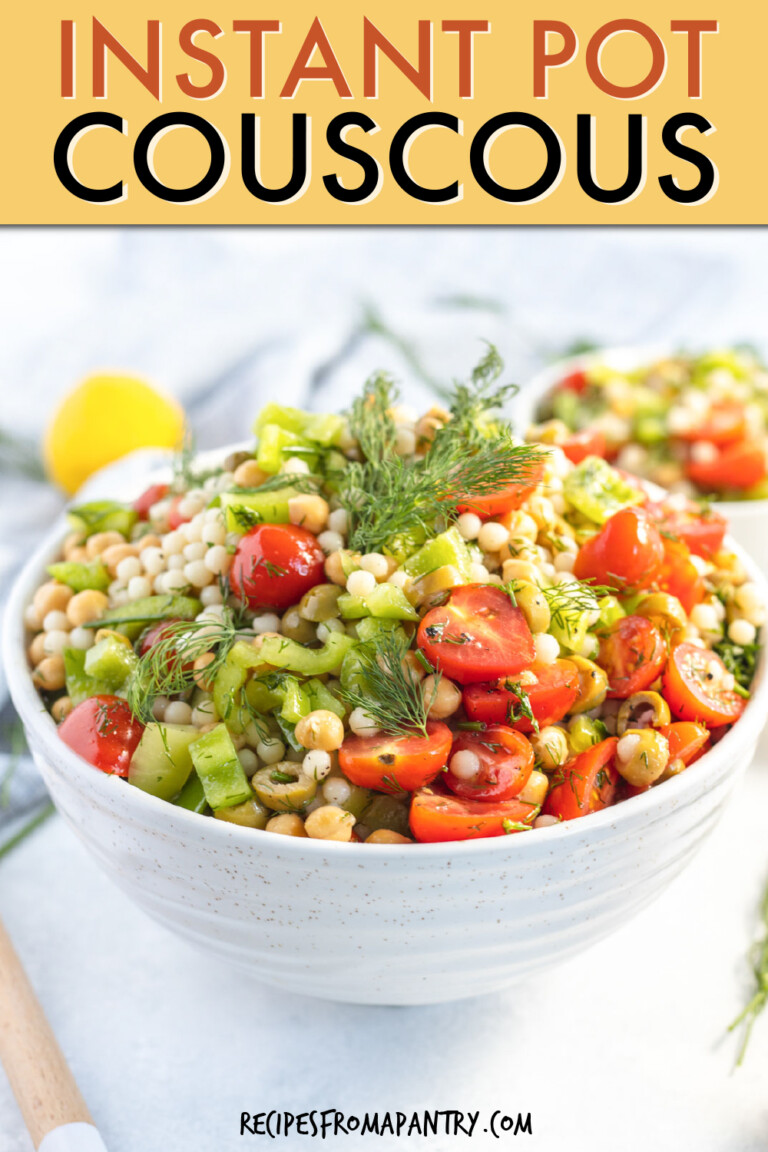 A bowl of Israeli couscous with vegetables, garnished with cherry tomatoes and dill