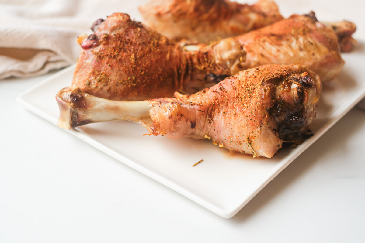 air fryer turkey legs on a white plate and ready to be served