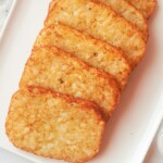 cooked frozen hash browns in oven stacked on a white serving tray