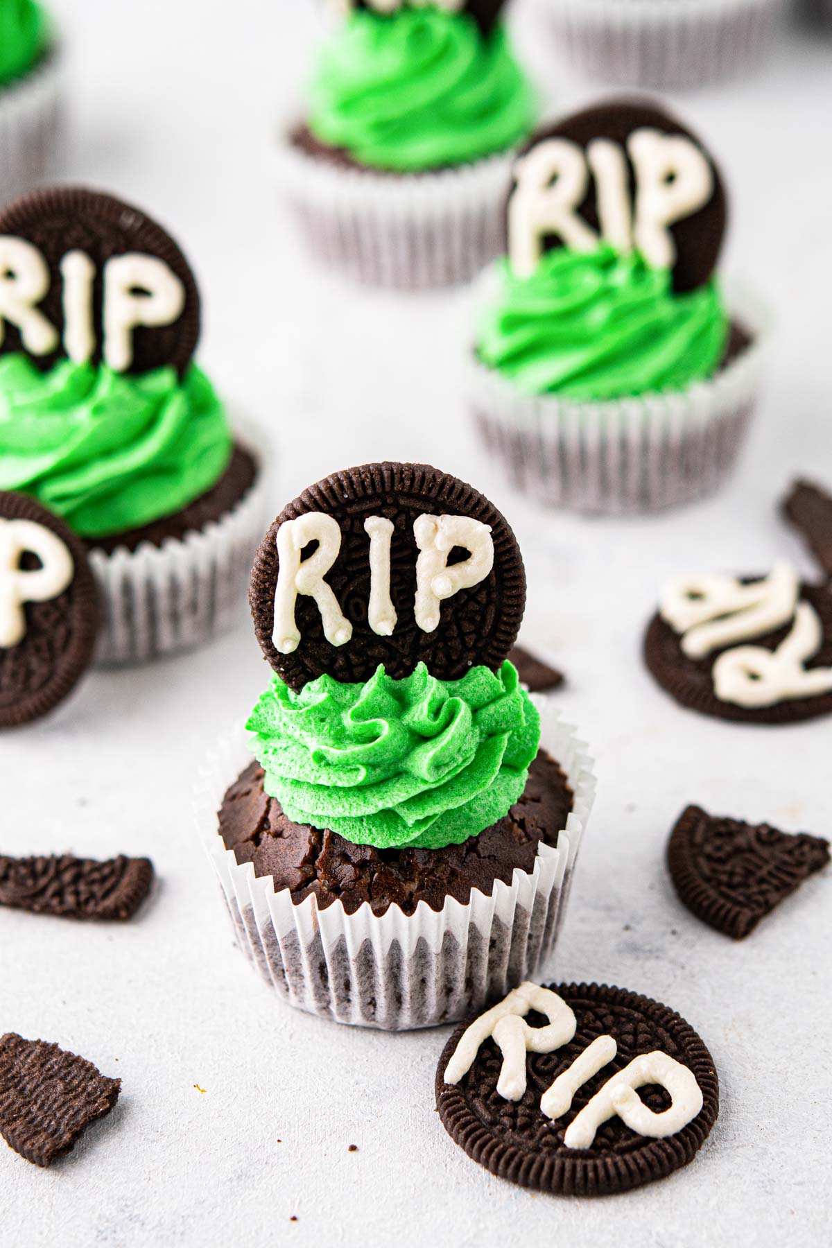 RIP Halloween Cupcakes on a table with extra cookie gravestone decorations