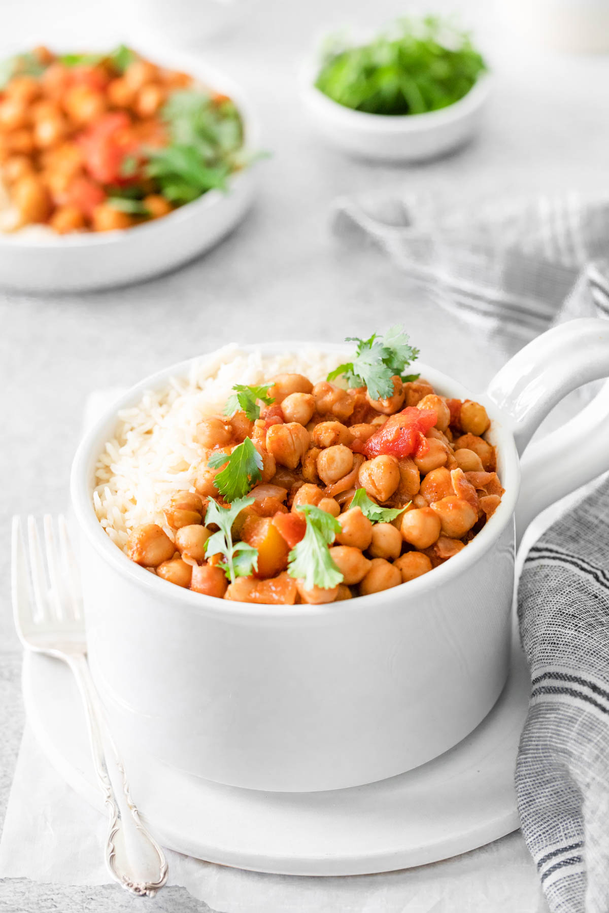 a white mug filled with a serving of the finished chana masala instant pot recipe