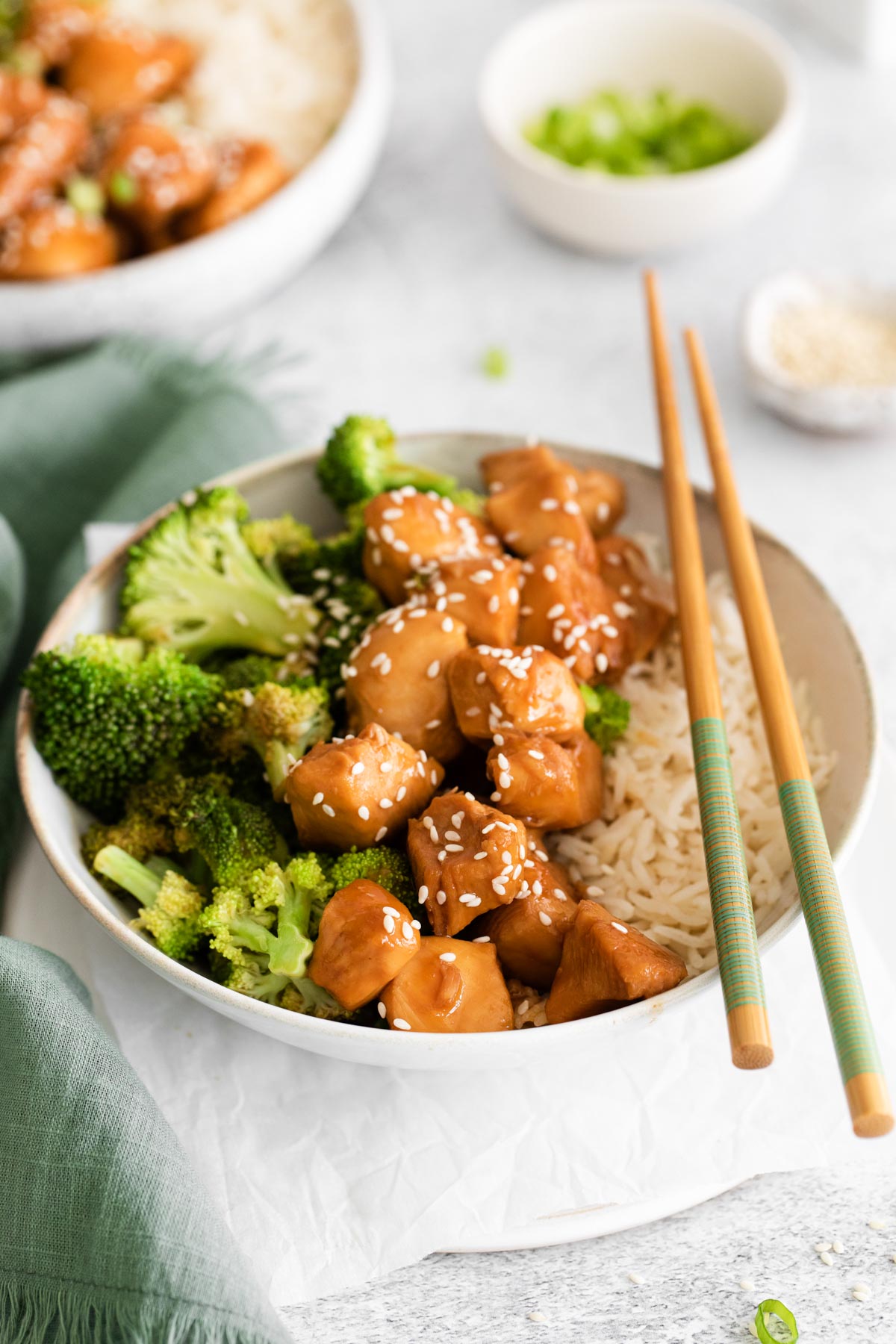 the finished instant pot teriyaki chicken in a bowl with rice and a set of chopsticks