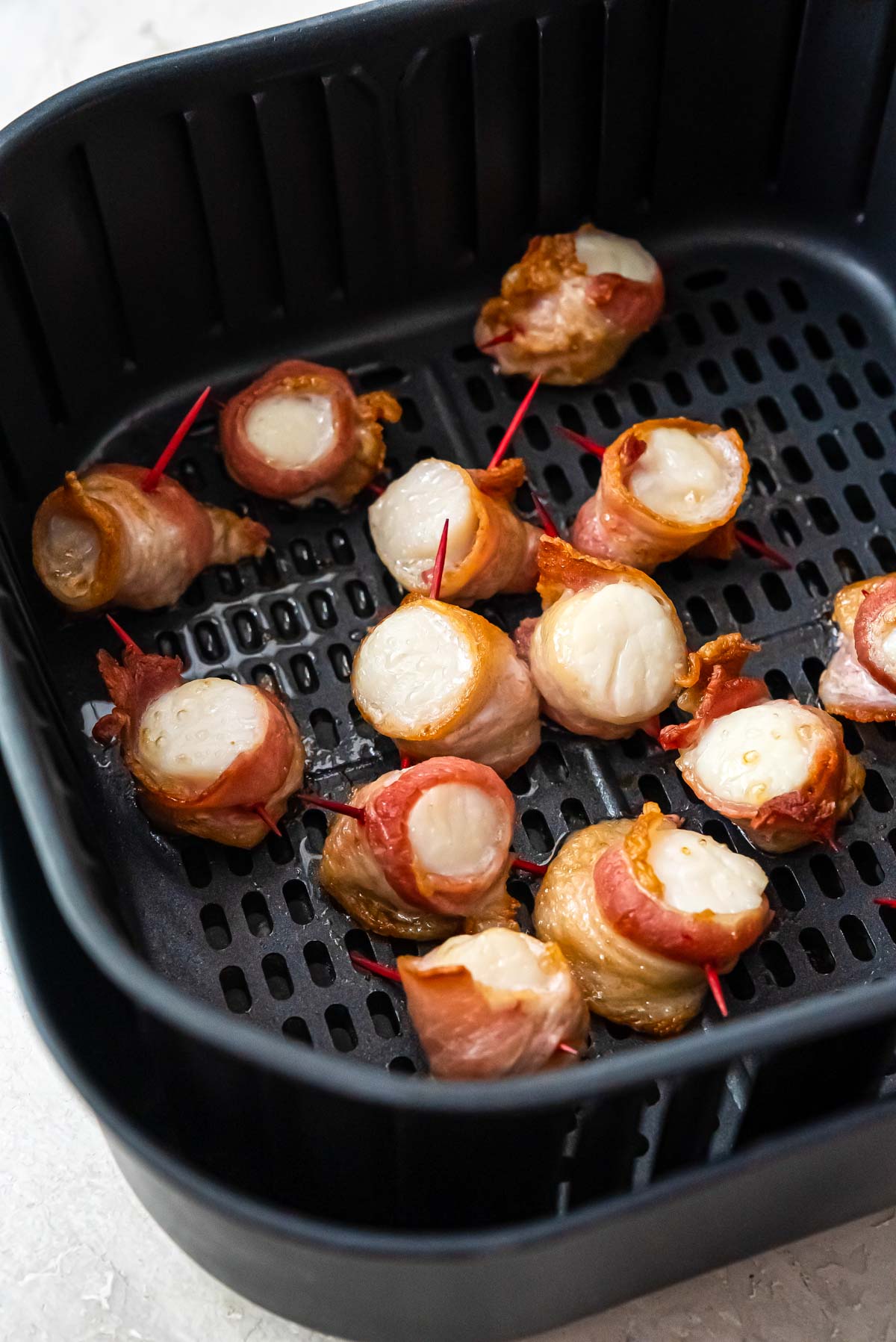 the finished bacon wrapped scallops in air fryer basket