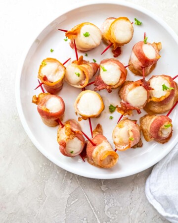 a plate filled with bacon wrapped scallops air fryer