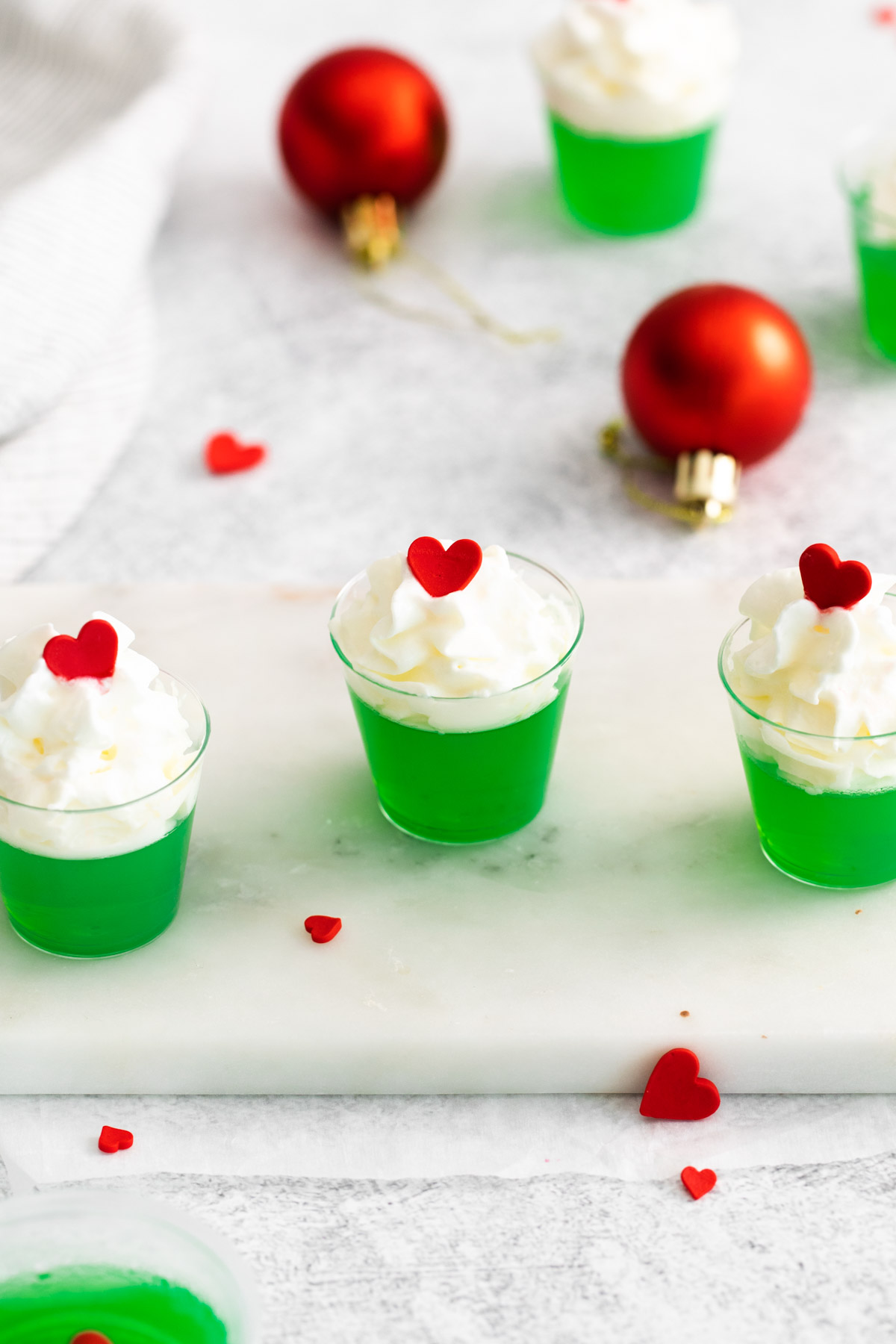 the completed grinch jello shots on a tray with red and green decorations