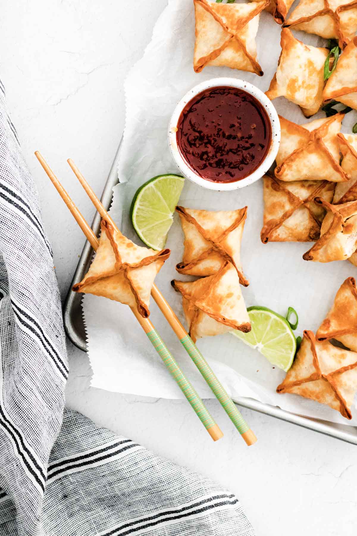 the finished air fryer crab rangoons served with chili sauce and chopsticks