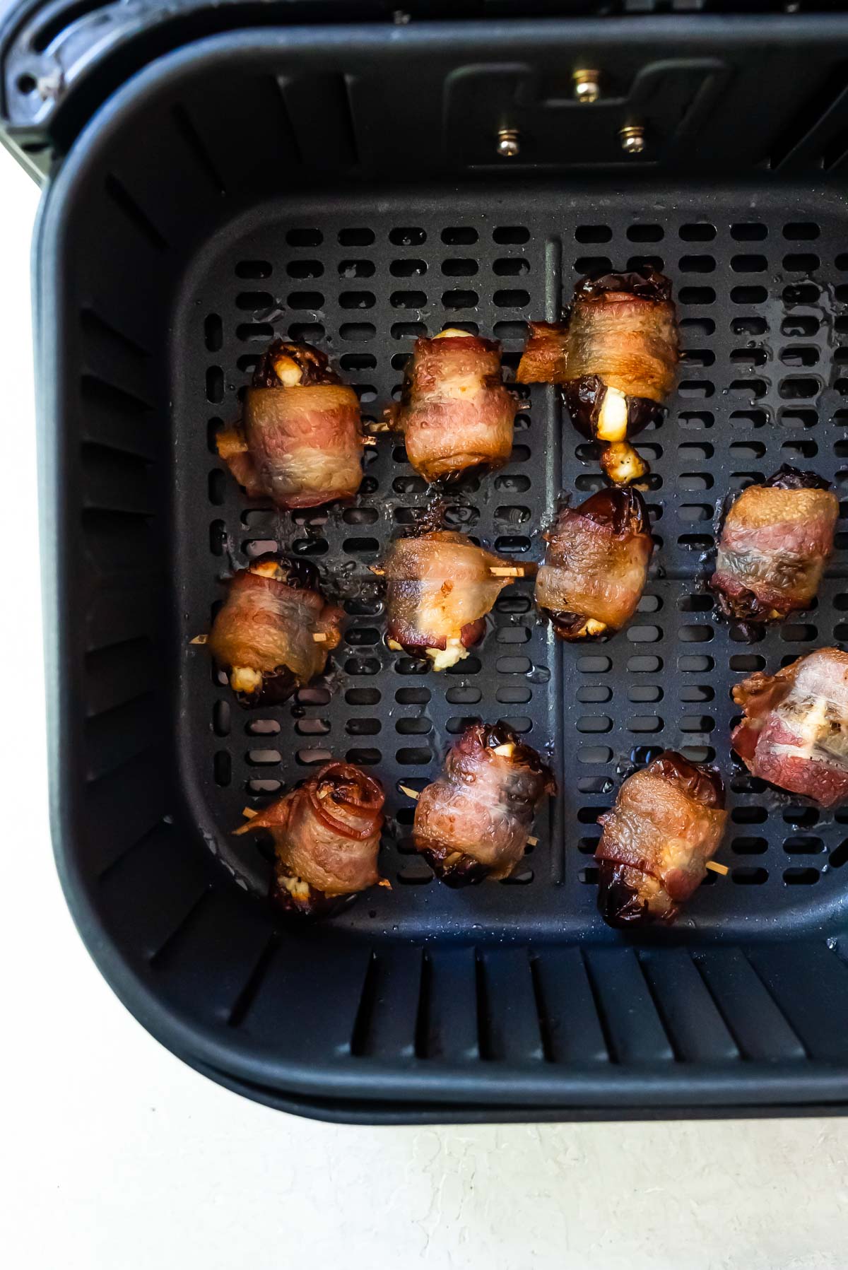 top down view of the cooked bacon wrapped dates air fryer basket