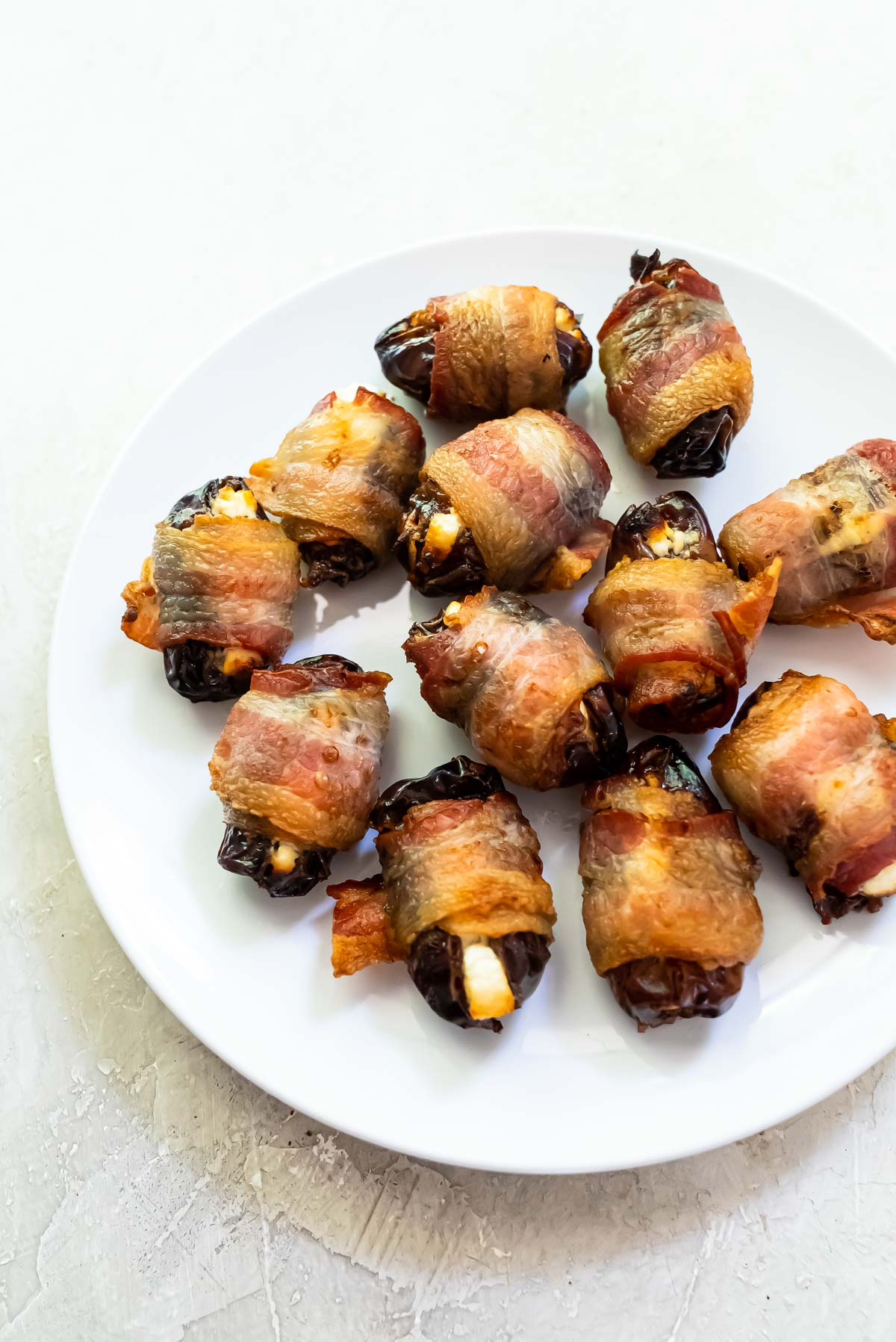 the completed air fryer bacon wrapped dates on a white plate