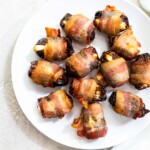 the finished bacon wrapped dates air fryer recipe served on a white plate with a cloth napkin
