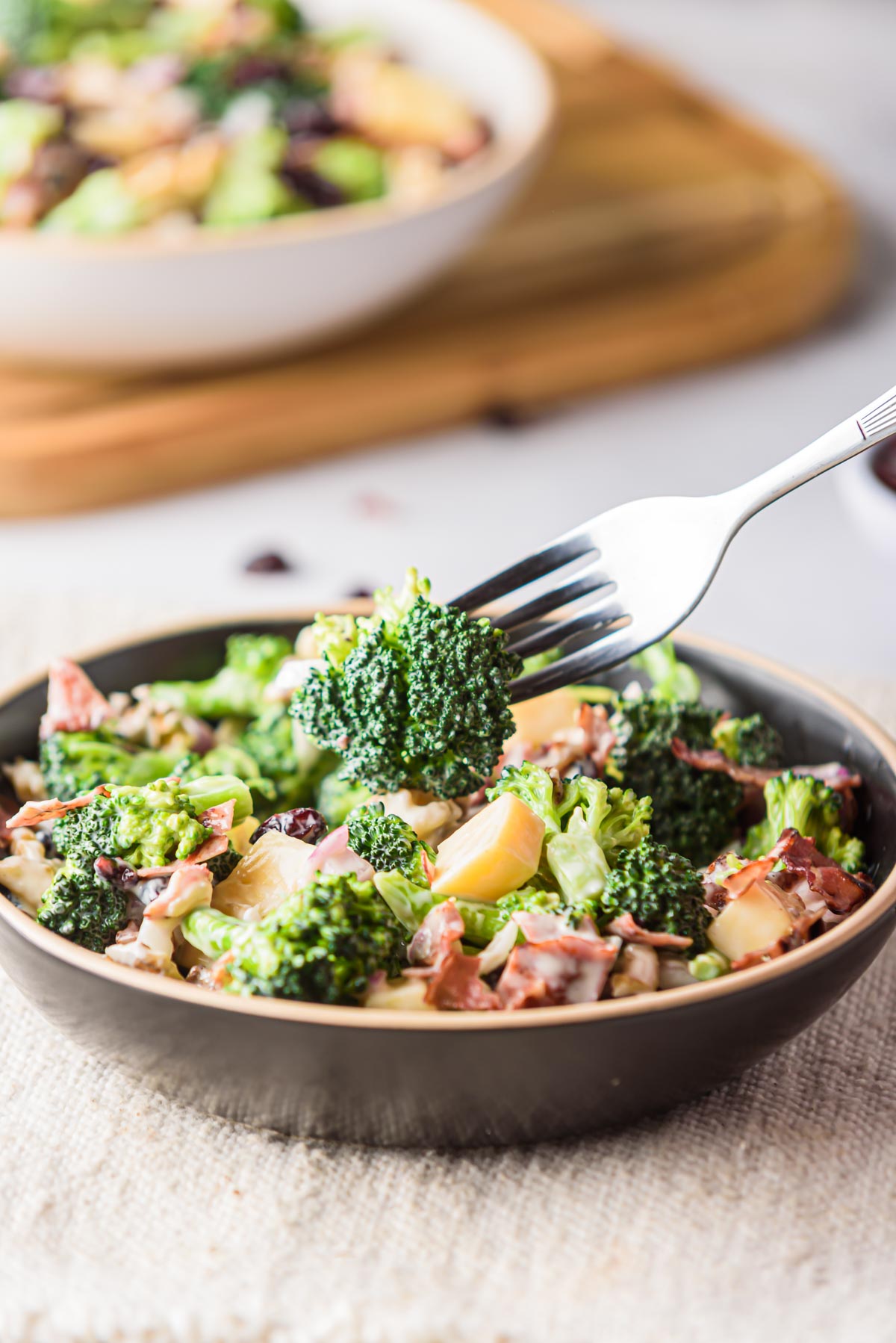 a fork removing one bite of broccoli cranberry salad