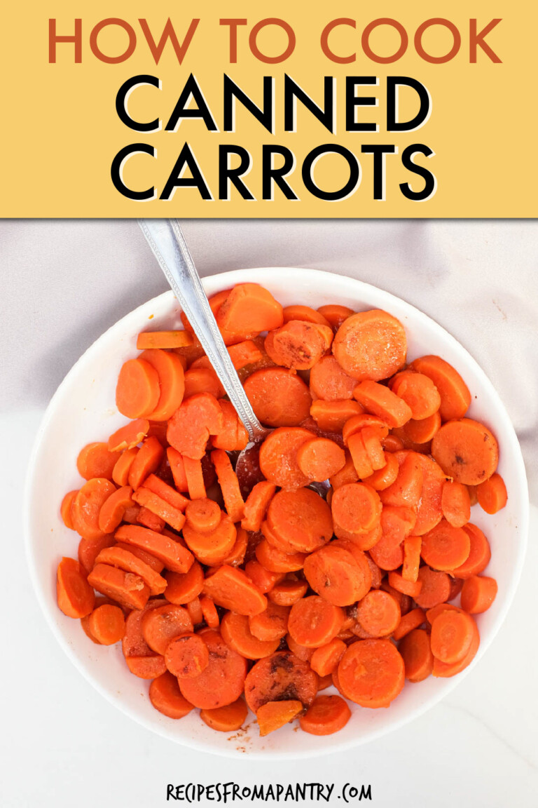 Sliced cooked carrots in a round bowl with a spoon.