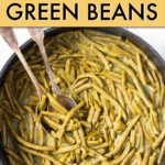 Canned green beans in a dish with serving utensils