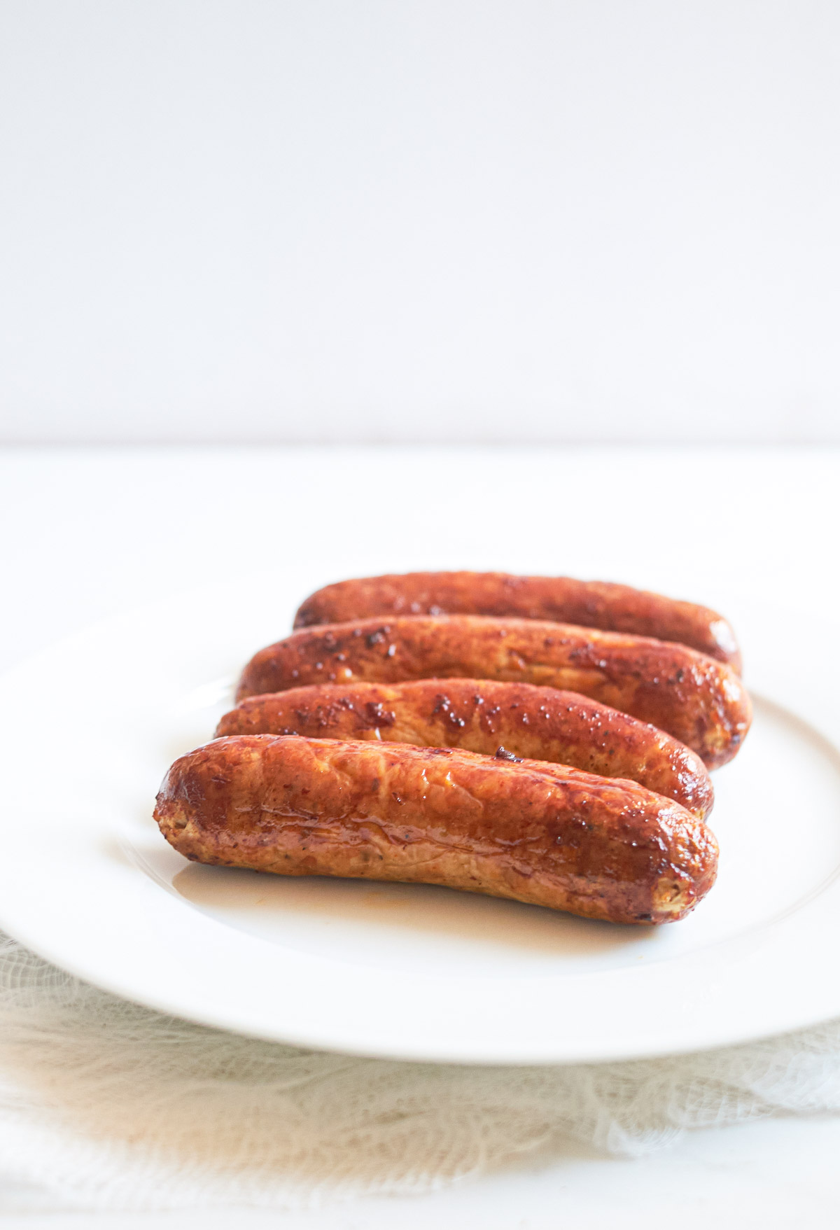 five Air Fryer Italian Sausages on a white plate