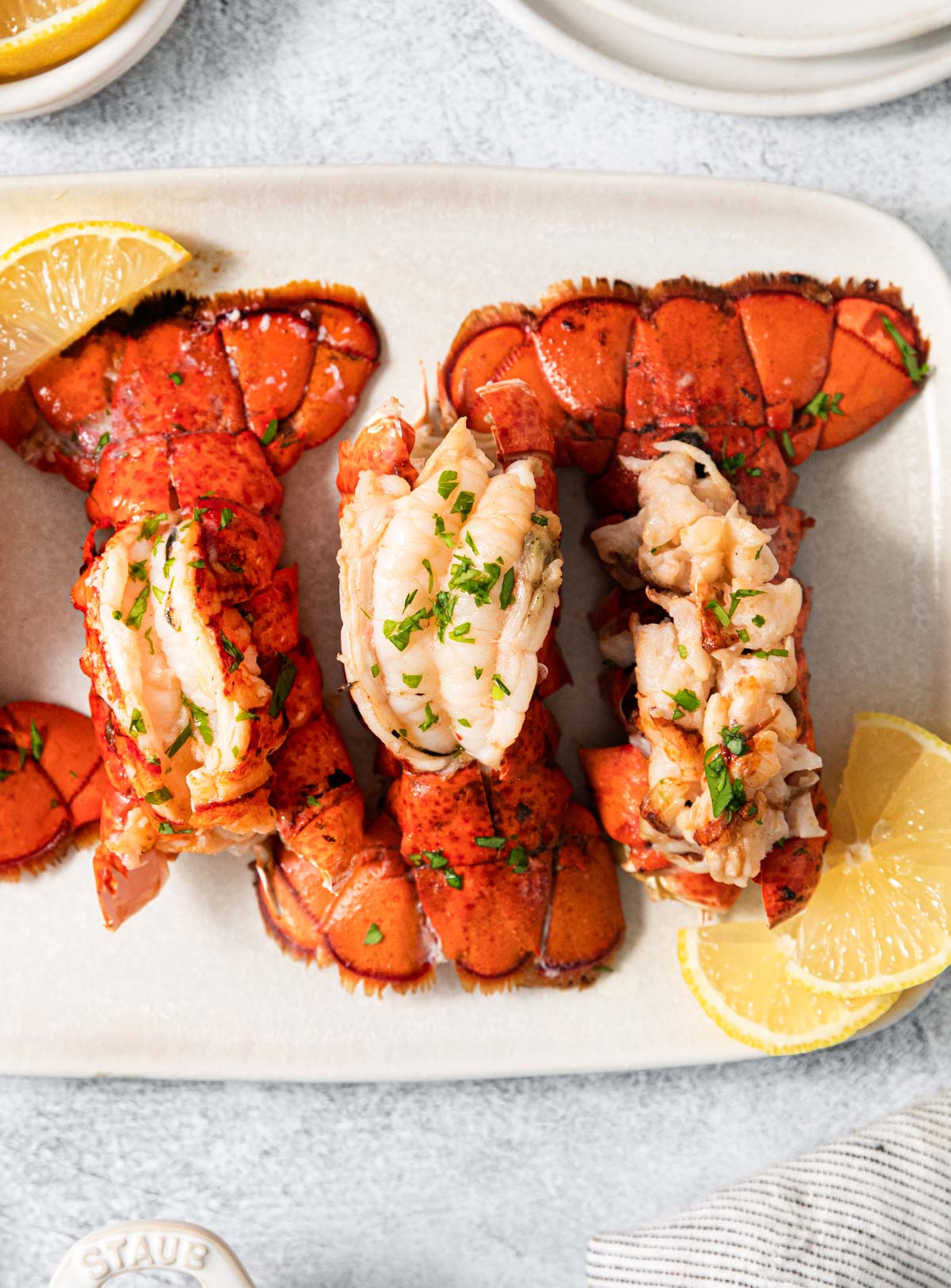 top down view of three air fryer lobster tail on a white plate