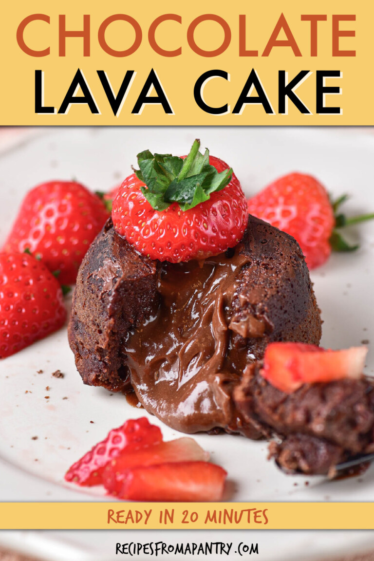 Small chocolate cake with liquid center cut into, garnished with berries