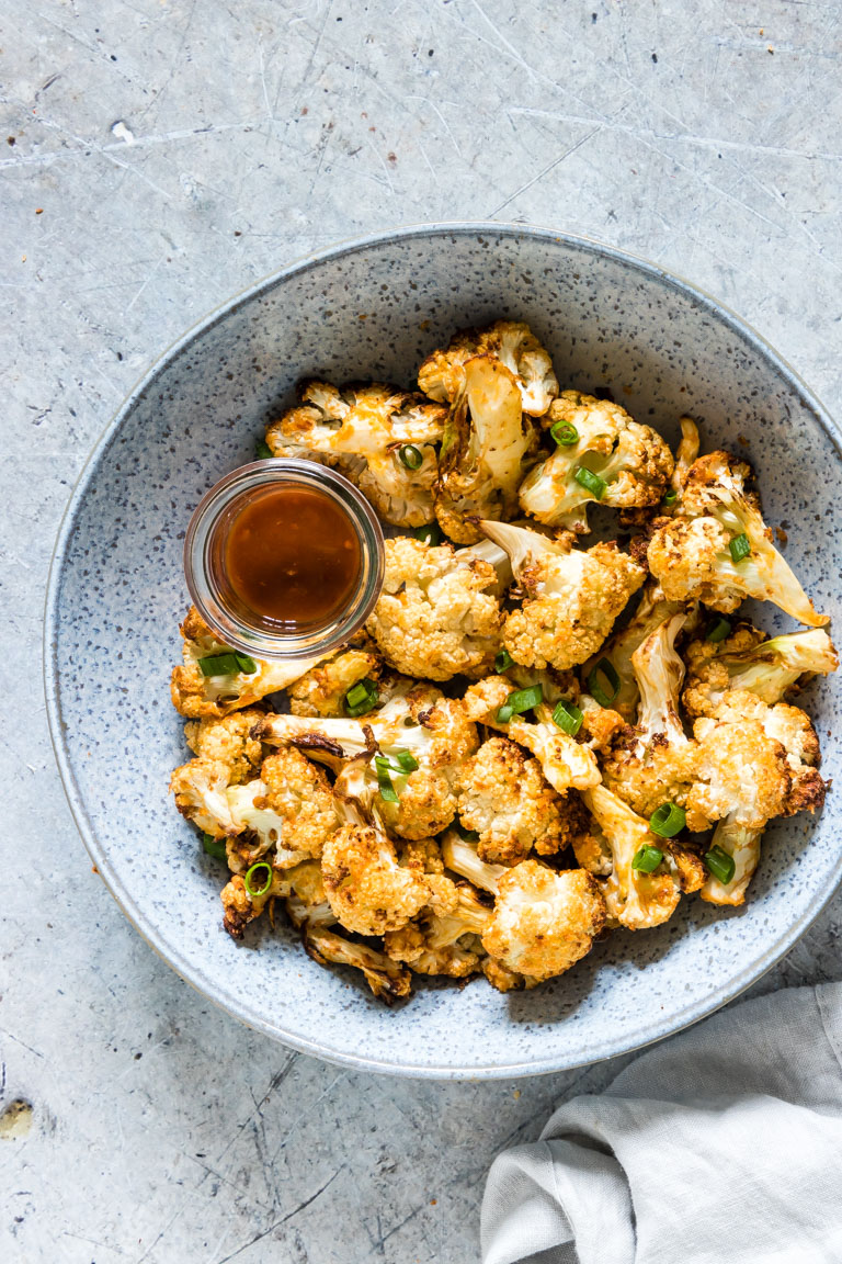 the finished cauliflower wings air fryer recipe in a ceramic bowl with cloth napkin