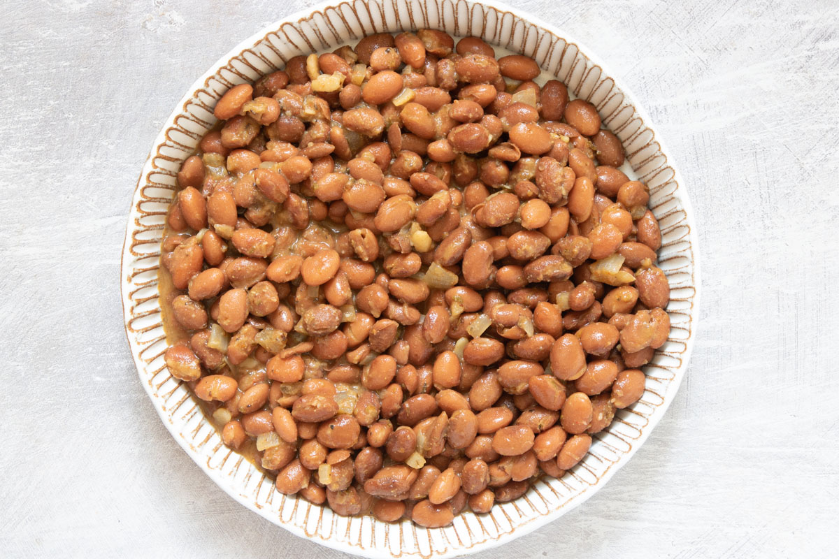 the completed how to cook canned pinto beans recipe in a ceramic bowl